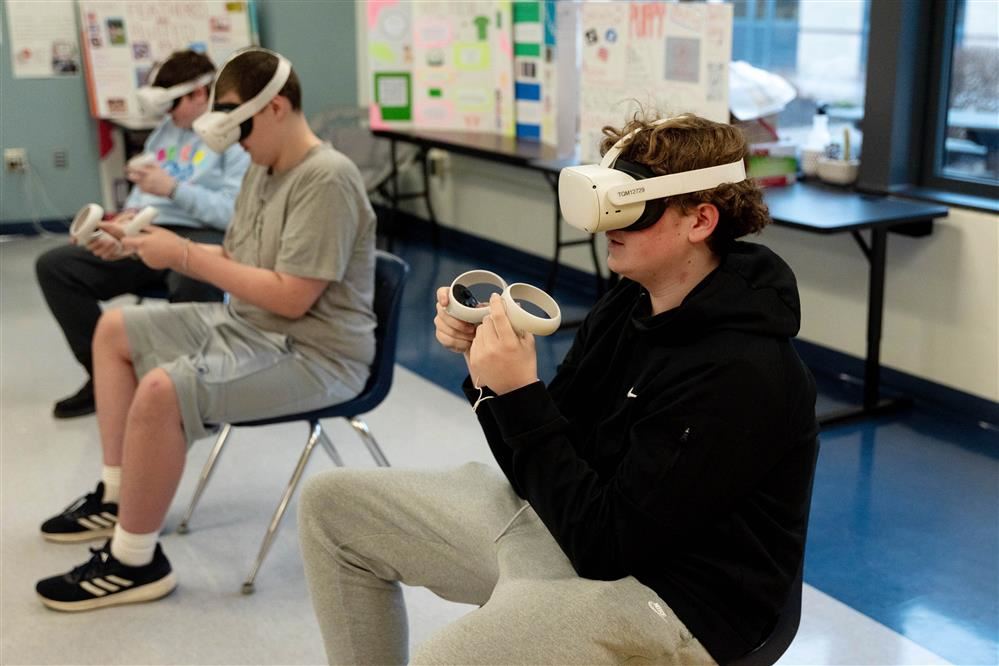  APW JSHS business students take turns wearing virtual reality headsets to try out different career 